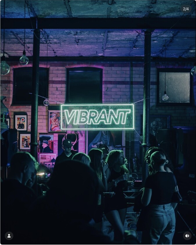 A crowd beneath the Vibrant sign during a pop-up night
