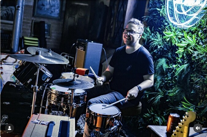 A drummer smiling during a live set at Peggy McCools